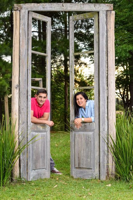 Pareja asomada a una puerta antigua en el jardín
