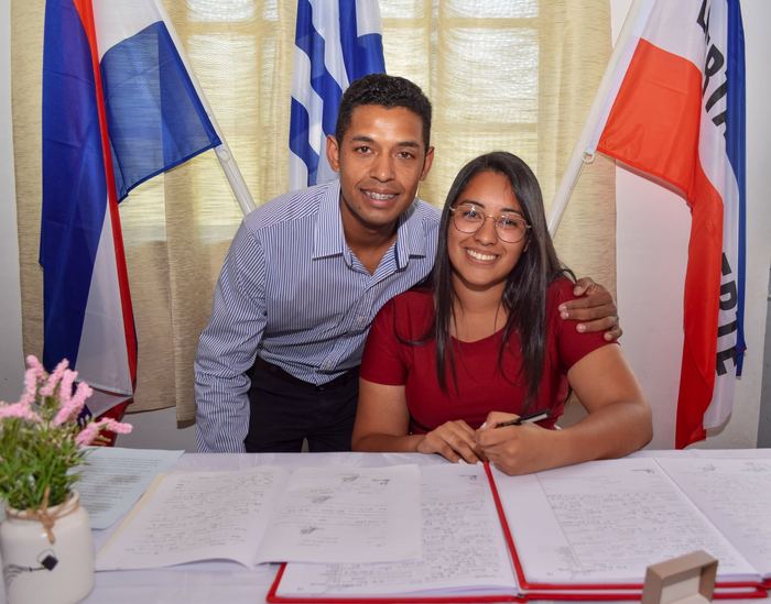 Pareja sonriendo al firmar en el registro civil
