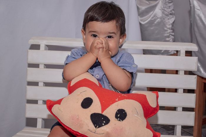 Nene tapándose la boca con las manos, sesión de primer añito