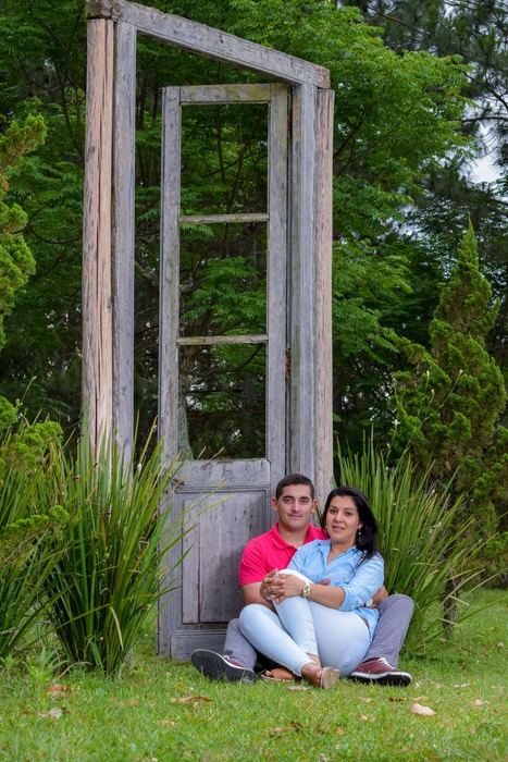 Pareja sentada al pie de una puerta antigua en el jardín