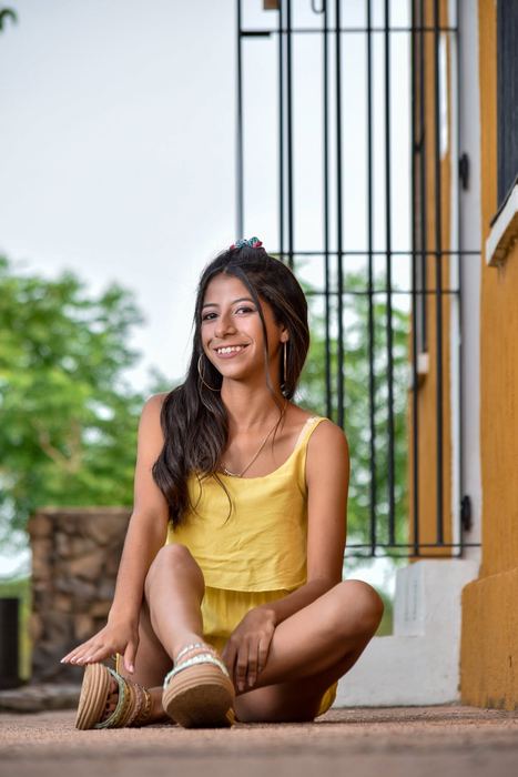 Quinceañera sentada en un escalón, sesión de exteriores