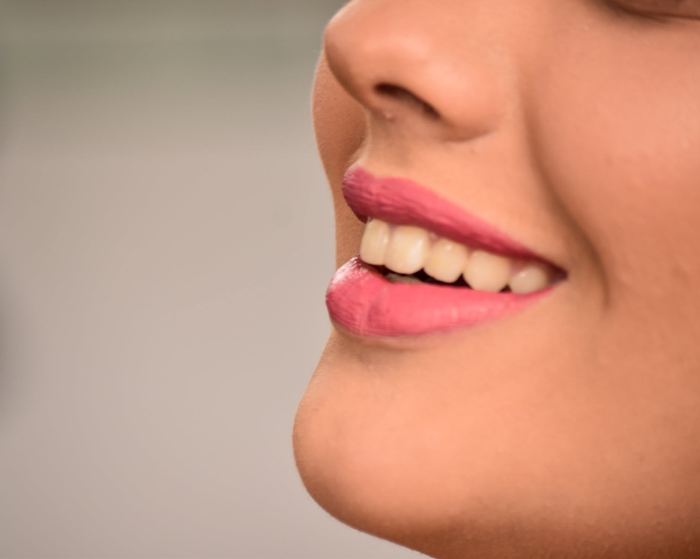 Primer plano de la sonrisa de la quinceañera maquillada